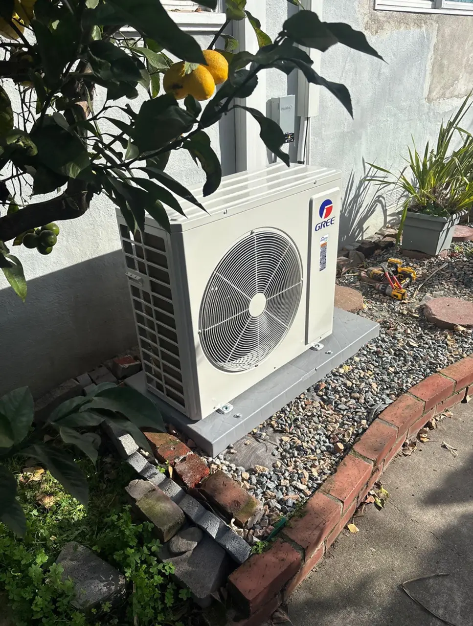 Heat pump installation with brick wall